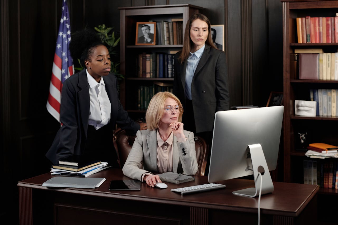 Three professional women working together in a business office environment.